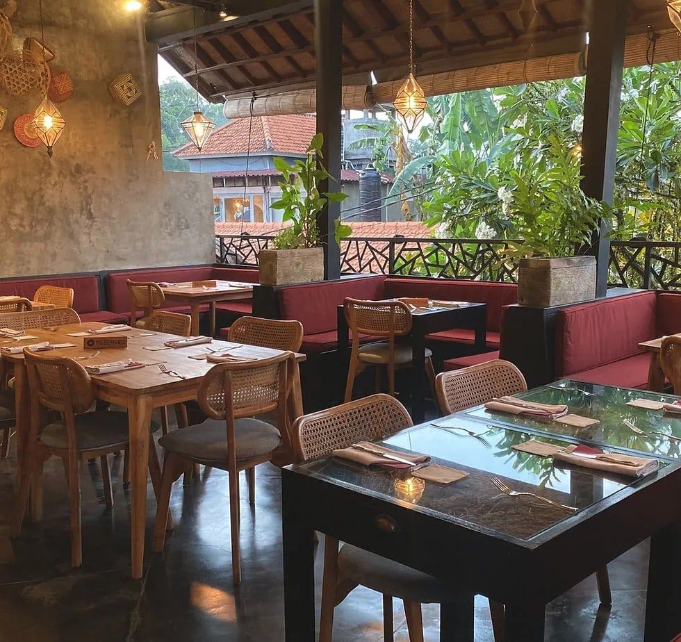 The dining room at Kusi in Ubud, with wooden tables and warm pendant lights