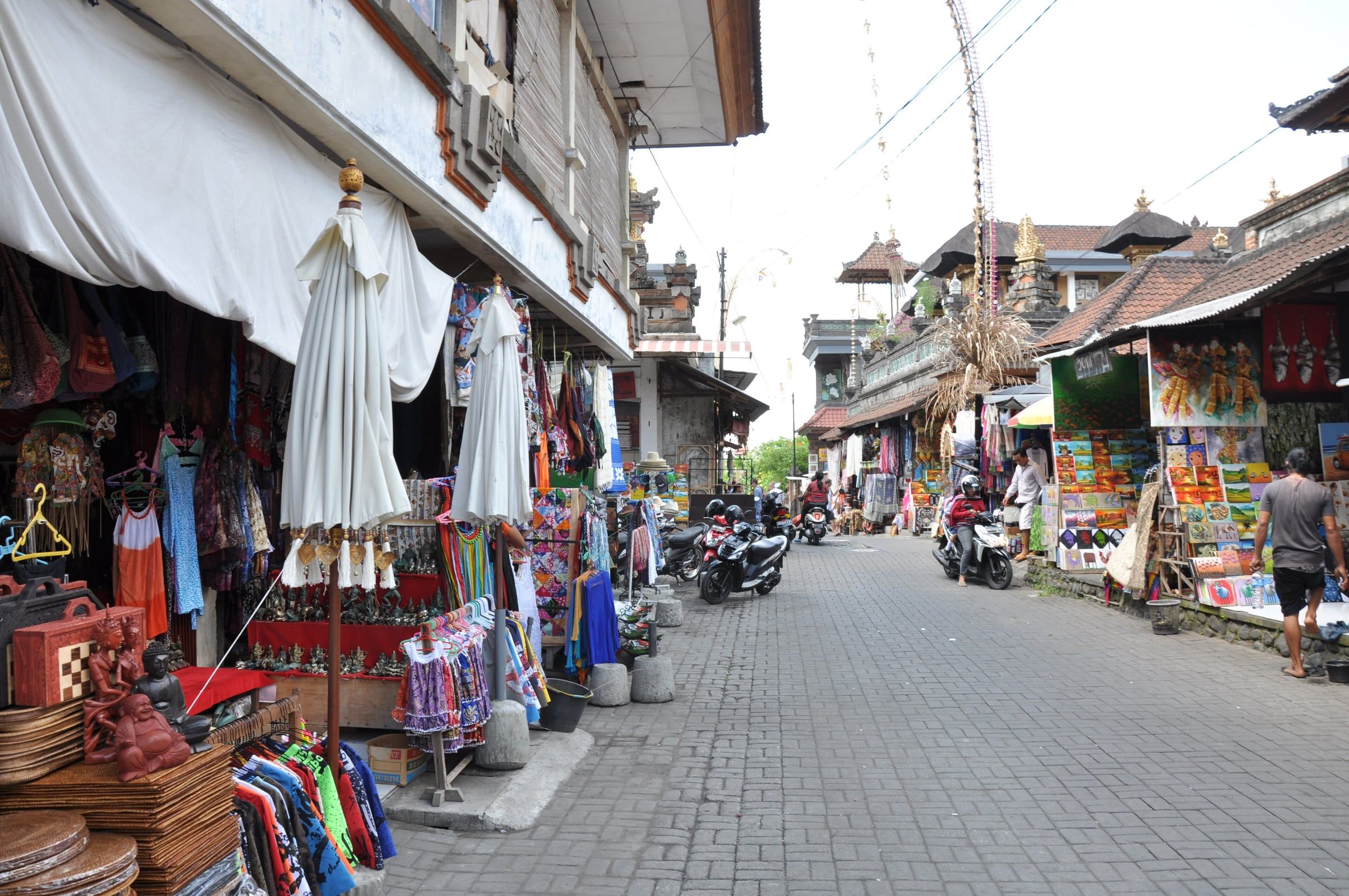Stalls of sarongs, bags and souvenirs along a street by the Ubud market
