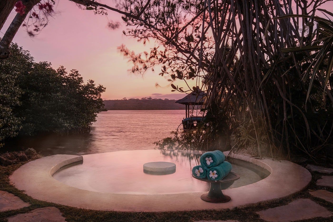 A private hot-spring pool at Mimpi Resort Menjangan at sunset, facing the mangroves
